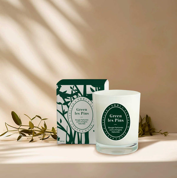 Bougie parfumée Green Les Pins Yodi avec sa boîte, sur une étagère au soleil