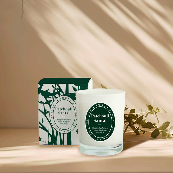 Bougie parfumée Patchouli Santal Yodi avec sa boîte, sur une étagère au soleil